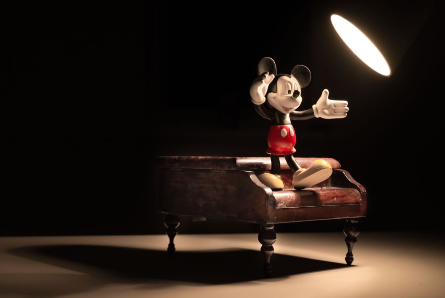 Mickey Mouse standing on a piano